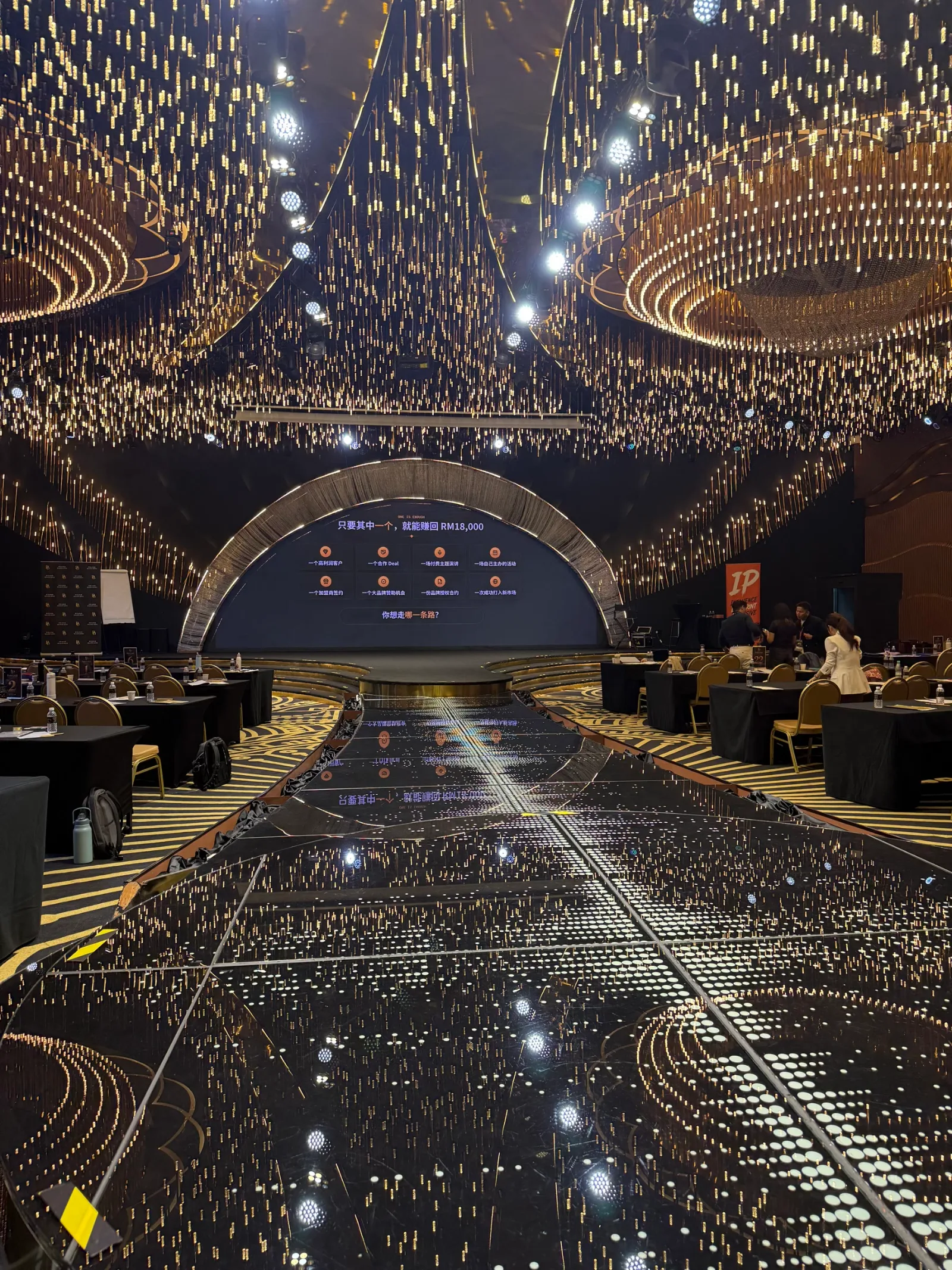 The glass runway at Confetti KL, lit from inside, leading to the stage under a ceiling of hanging lights
